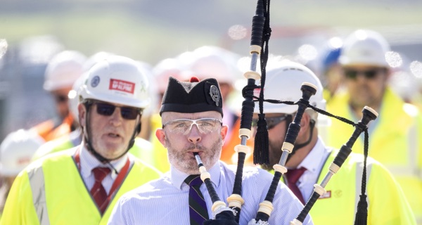 A piper leads the ceremony