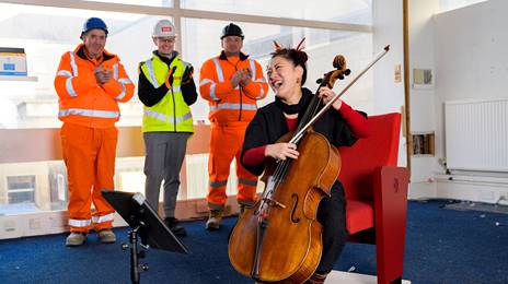 Su-a-Lee playing cello for construction workers