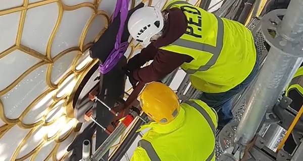 people working on the clockface of Elizabeth Tower