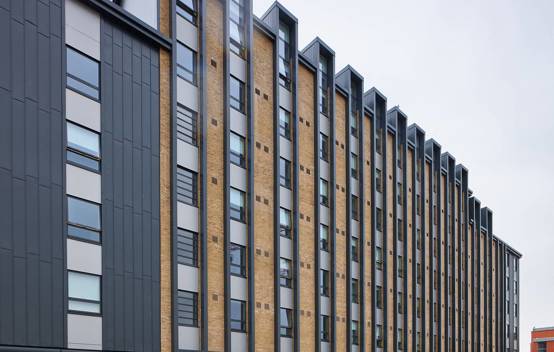 Side view of the building, displaying multiple window openings and clean, modern architectural lines.