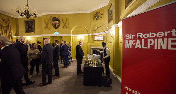 Guests assembled inside the Honourable Artillery Company with a Sir Robert McAlpine banner in the forefront