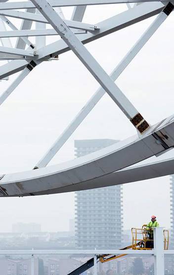 Cranes lifting prefabricated roof truss sections into place at the Emirates Arena